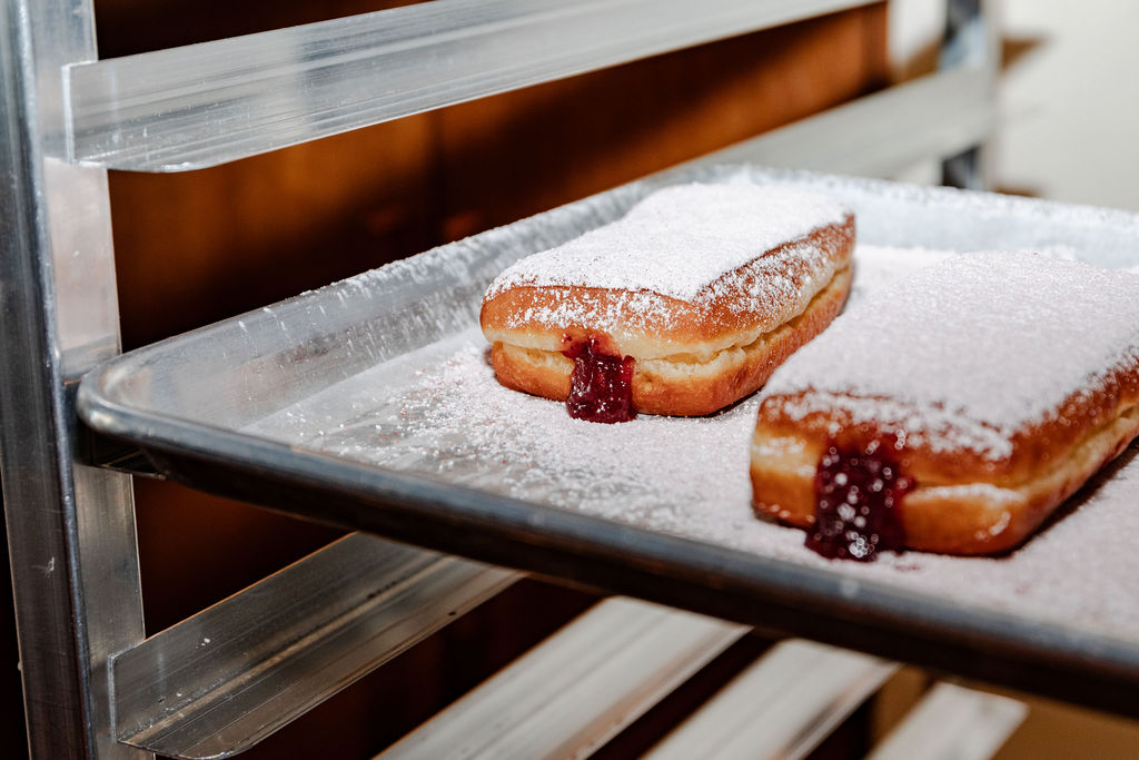 Powdered jam-filled donas on a tray
